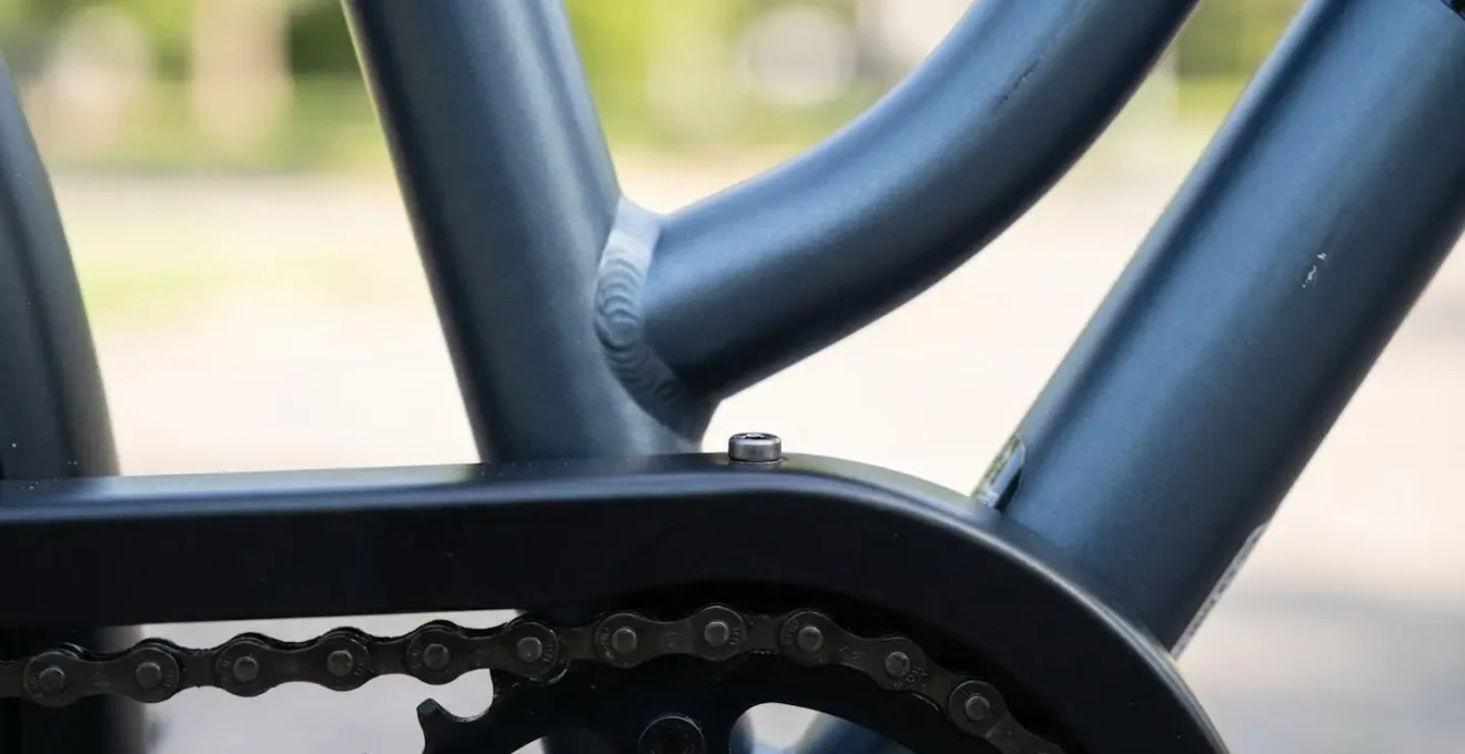 Gros plan détaillé sur la protection de chaîne intégrale d'un vélo hollandais, mettant en valeur la robustesse et la finition soignée du carter métallique